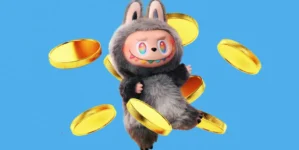 A cartoonish character in a fluffy, grey, animal-like costume with large, colorful eyes and a wide, toothy grin. It is surrounded by several floating golden coins against a blue background.